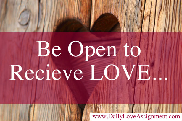 Minimalist gray line drawing of a hand holding a heart shape.