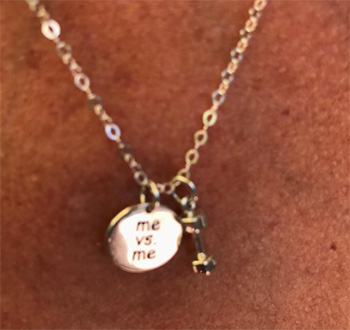 Minimalist gray line drawing of a hand holding a heart shape.