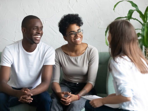 Three people engaged in a friendly conversation indoors.